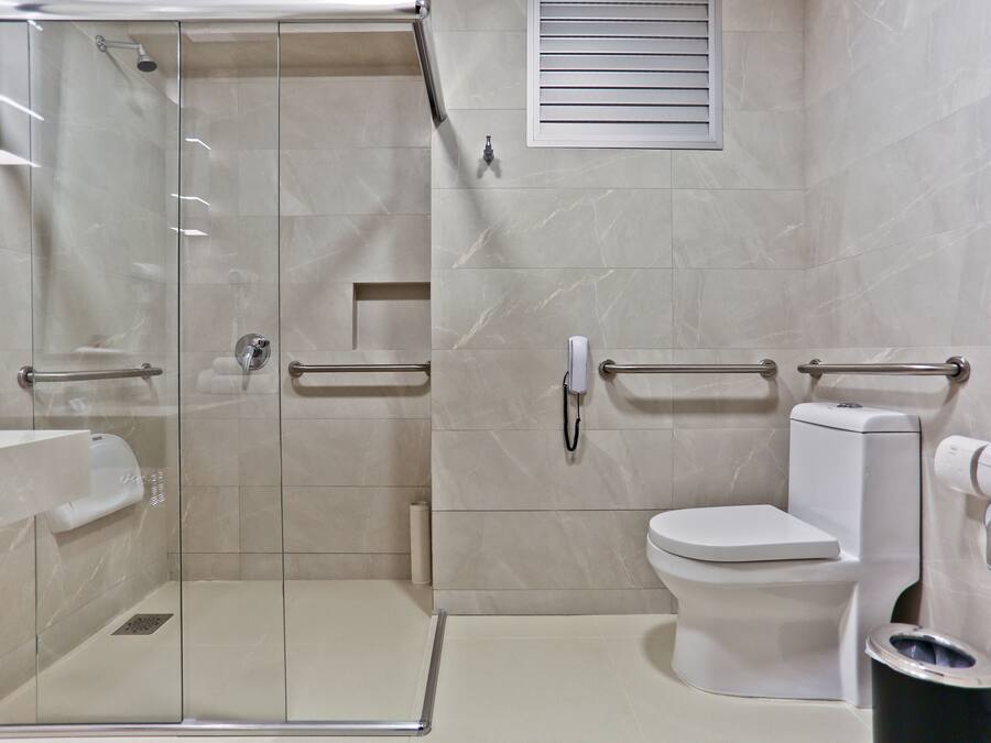 Une salle de bain moderne dotée d’une douche à parois de verre, de toilettes et d’un bidet.