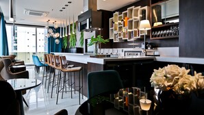 A modern kitchen with a central island, bar area, and seating for dining. - Sandri Palace Hotel (Itajai)