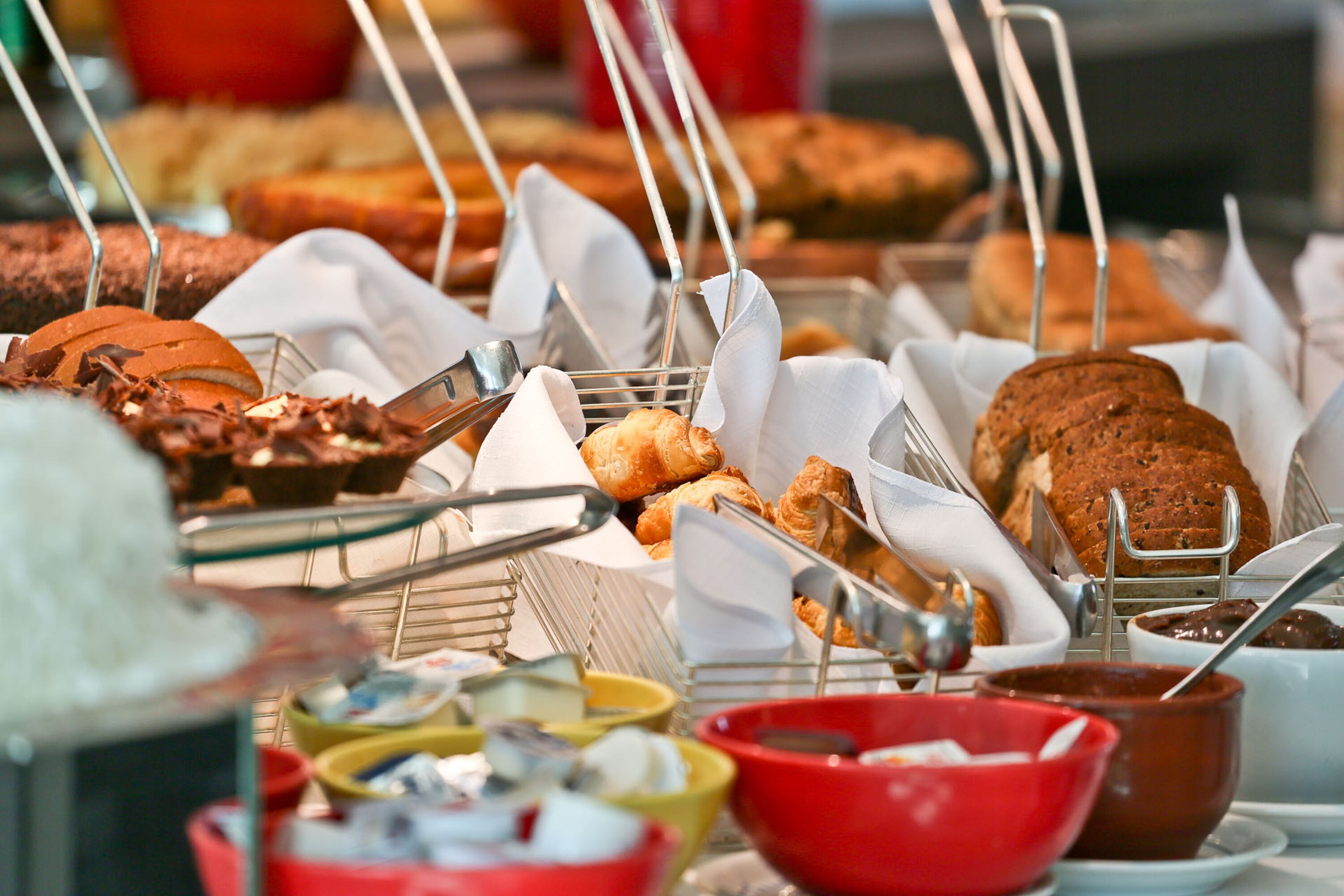 A buffet with various baked goods and condiments.