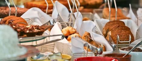 A buffet with various baked goods and condiments.