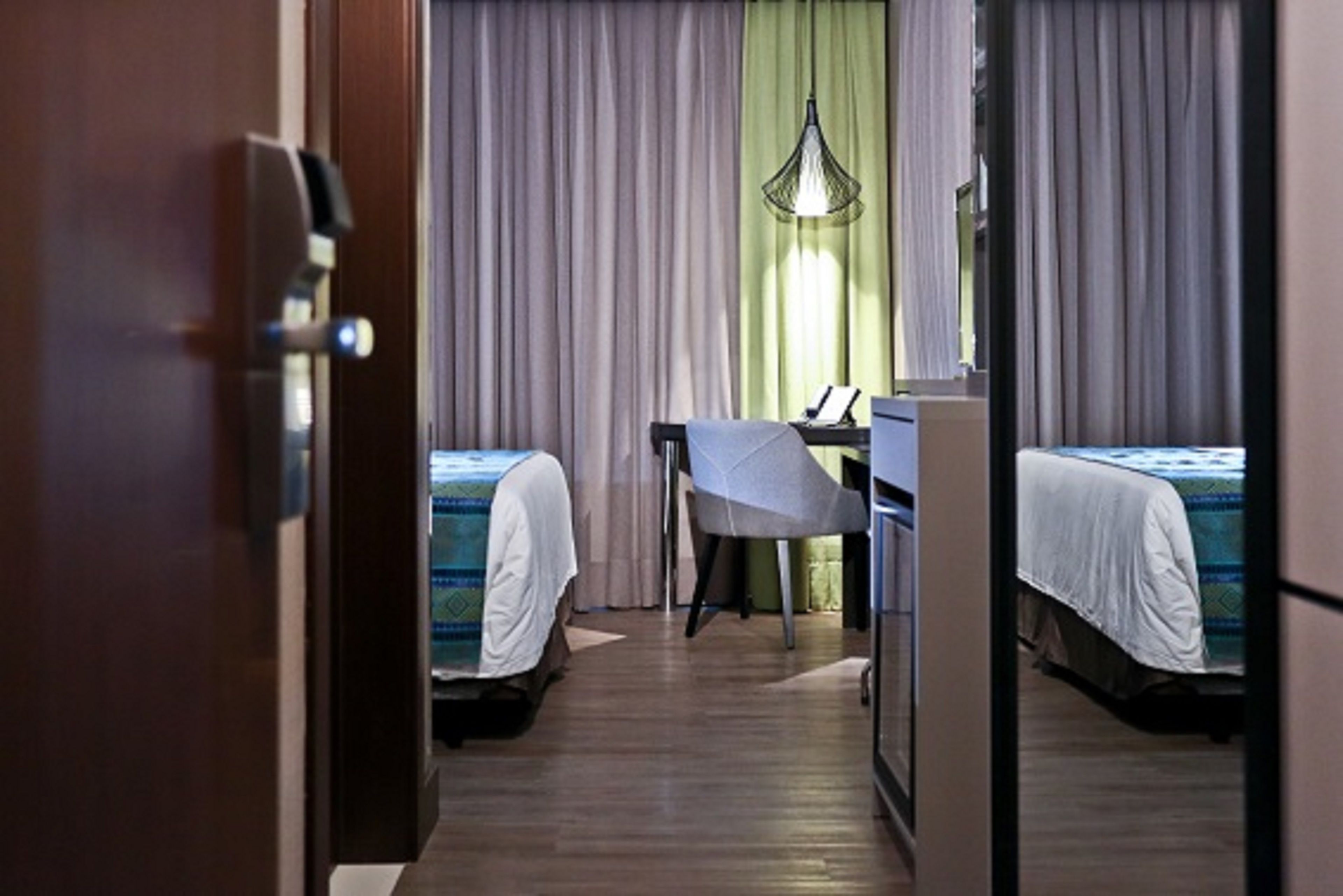 Habitación de hotel con dos camas, un escritorio y una silla.