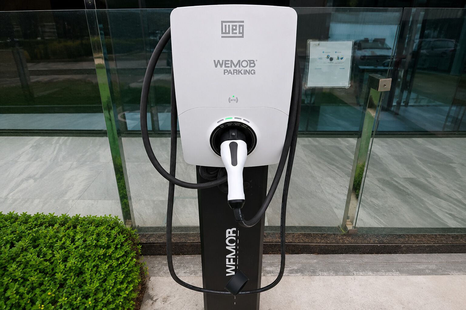 A WEMOB PARKING station with a charging cable connected.