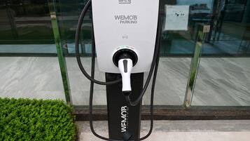 Estación WEMOB PARKING con un cable de carga conectado.