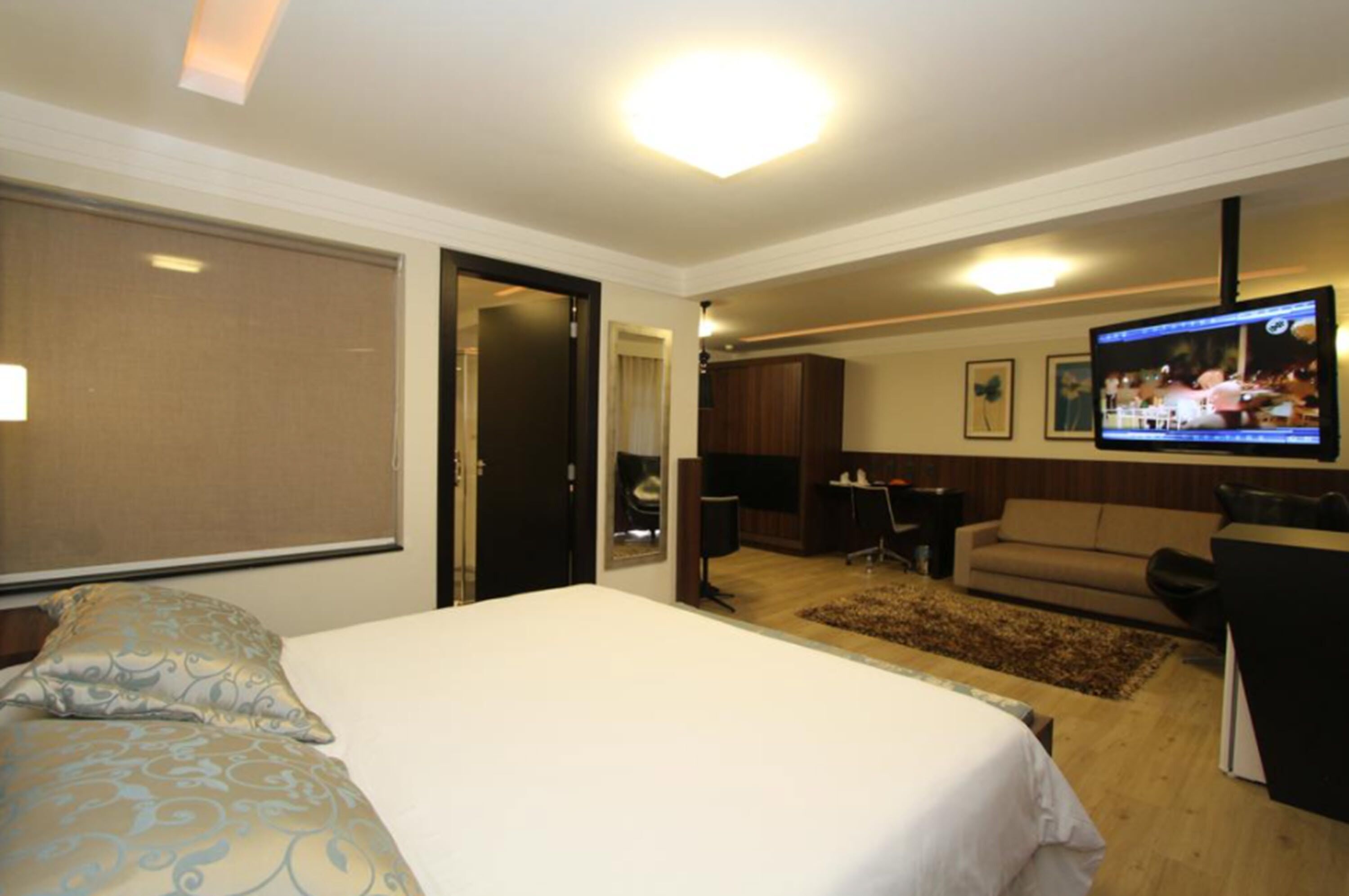 Une chambre d’hôtel équipée d’un lit, d’une télévision, d’un canapé et d’un bureau.