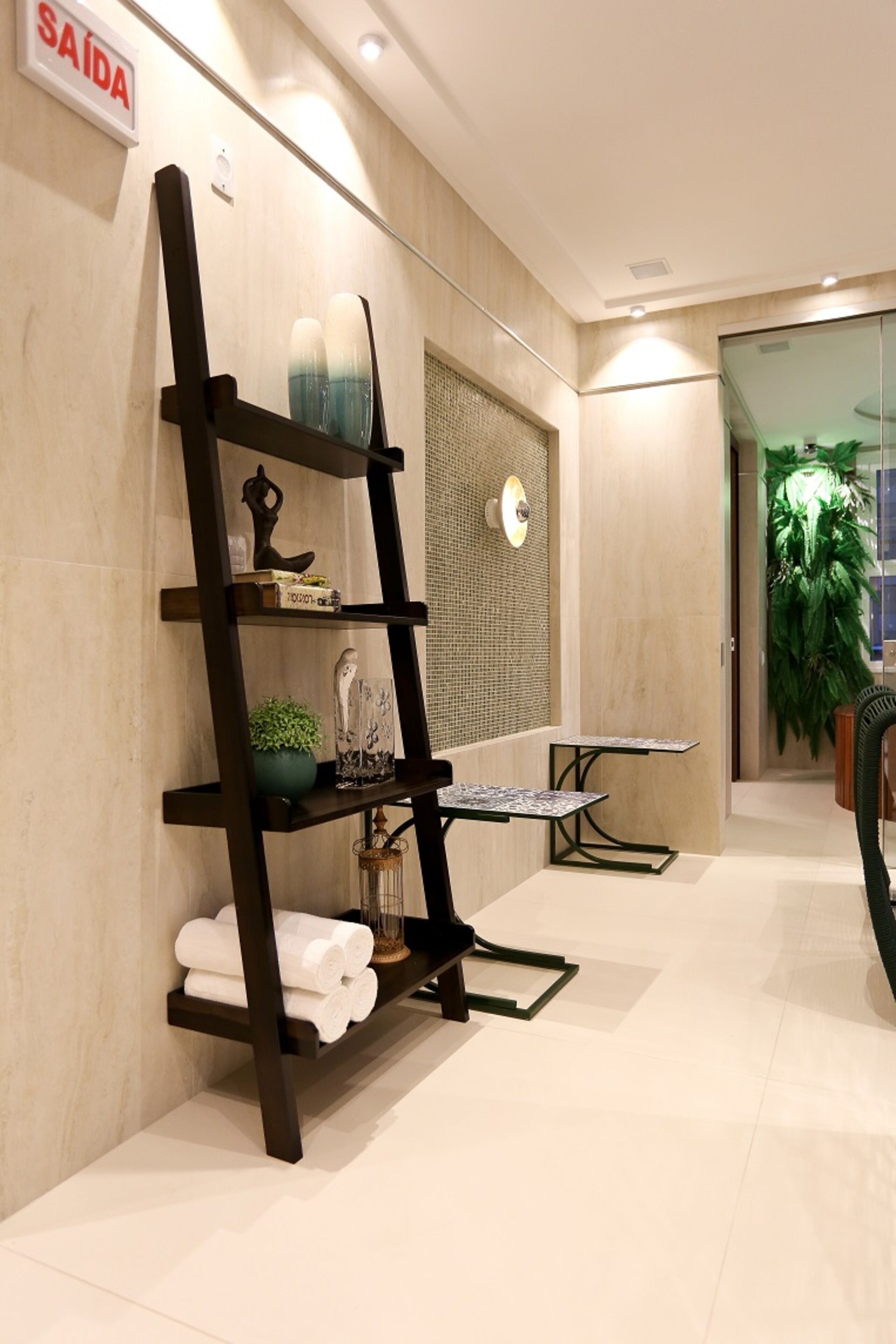 A modern bathroom with a black shelf unit, a mirror, and a sign indicating the exit.