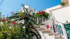 Un edificio blanco con una escalera curva y una puerta verde.