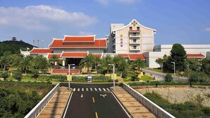 A traditional building with a red roof and a modern structure with a beige facade. - Quanzhou Guest House Hotel (Quanzhou)