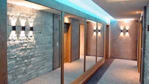 A hallway with mirrored walls and wooden doors, leading to individual rooms. - Brugger´s Genießerhotel Lanersbacherhof (Tux)