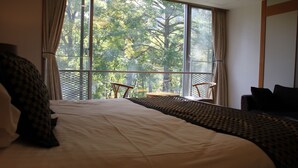 A hotel room with a large window, a bed, a small table, and a chair. - The Ridge Hotel & Apartments (Hakuba)