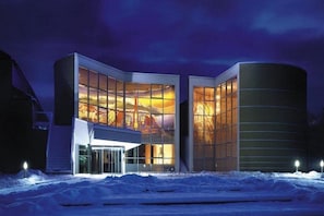 A modern building with a glass facade and a curved structure. - St. Virgil (SALZBURG)