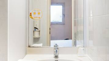 A bathroom with a white sink, mirror, and towel rack.