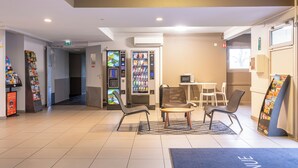 Eine Lobby mit Verkaufsautomaten, Sitzgelegenheiten und einer Rezeption.