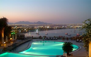 A swimming pool with a view of a cityscape at dusk. - Eden Rock Hotel (Sharm El Sheikh)