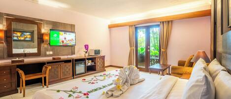 A hotel room with a bed, a desk, a television, and a window with curtains.