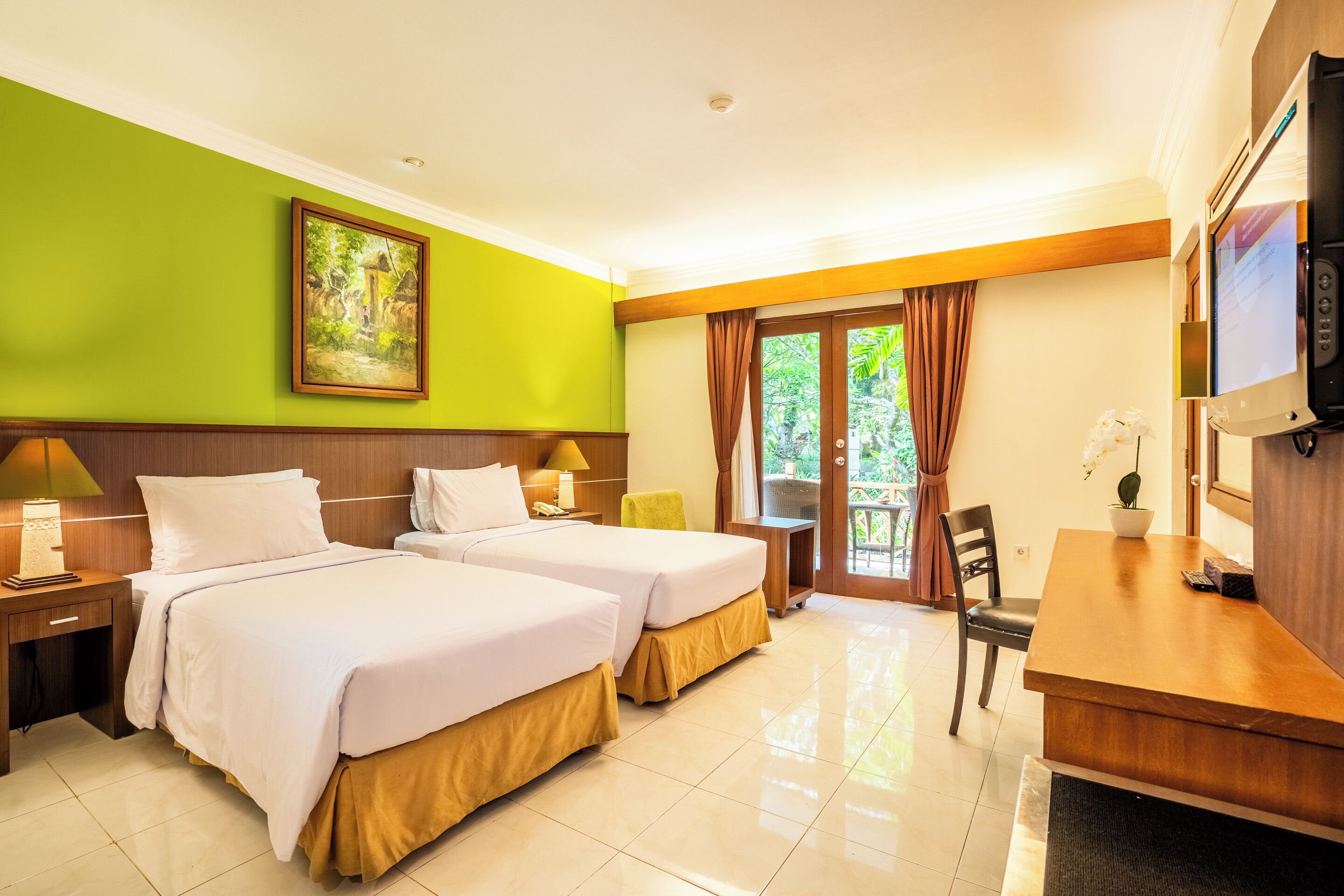 A hotel room with two beds, a desk, a television, and a window with curtains.