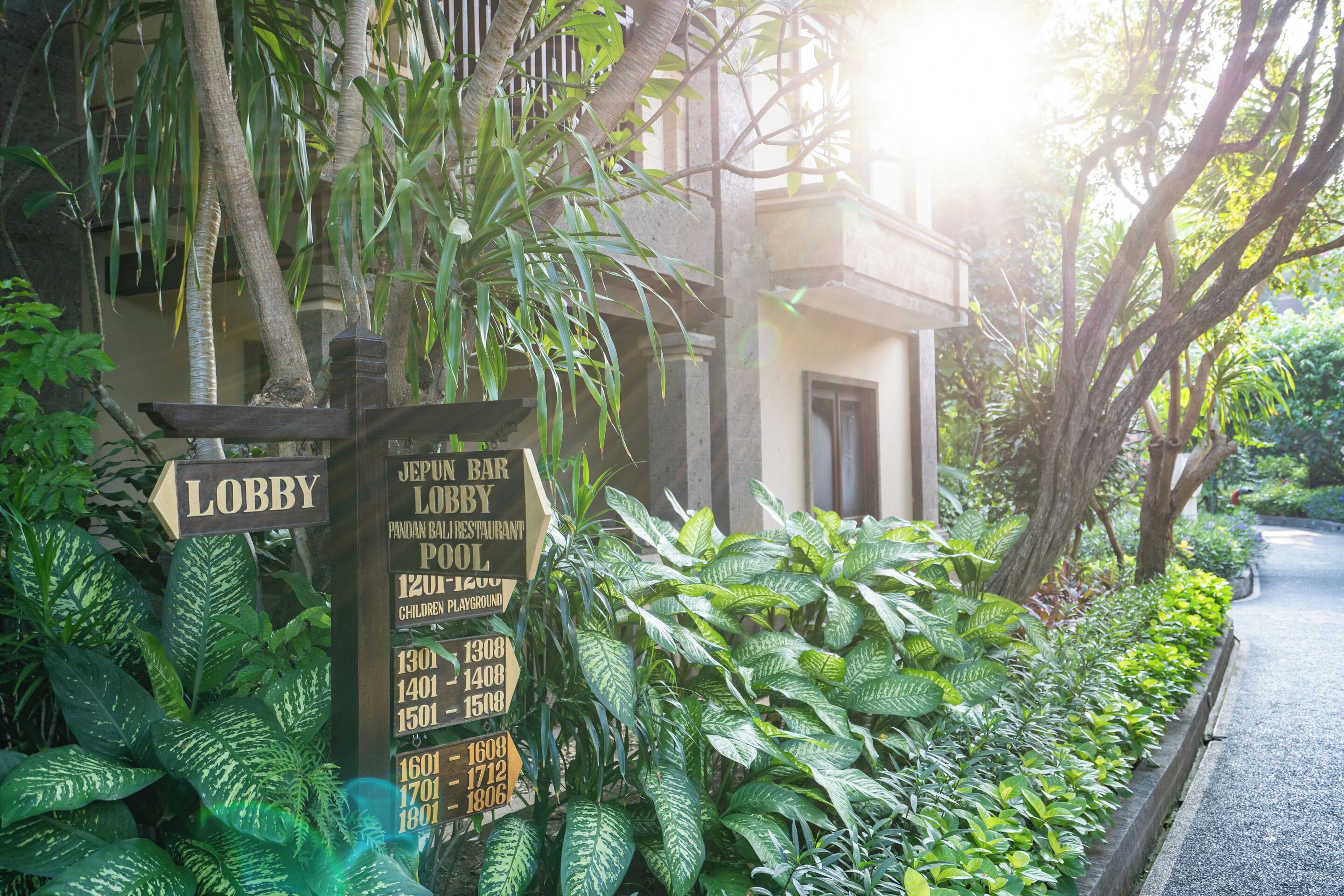 A signpost with directions to various facilities including a lobby, bar, restaurant, pool, and children's playground.