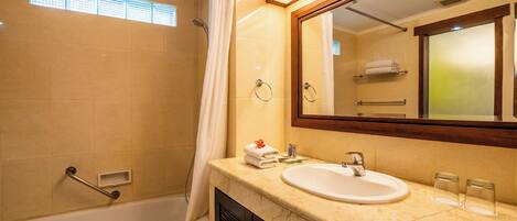 A bathroom with a bathtub, a sink, and a mirror.