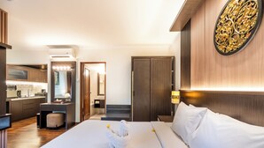 A hotel room with a large bed, a desk, a mirror, and a bathroom visible through an open door. - Risata Bali Resort and Spa (Kuta)