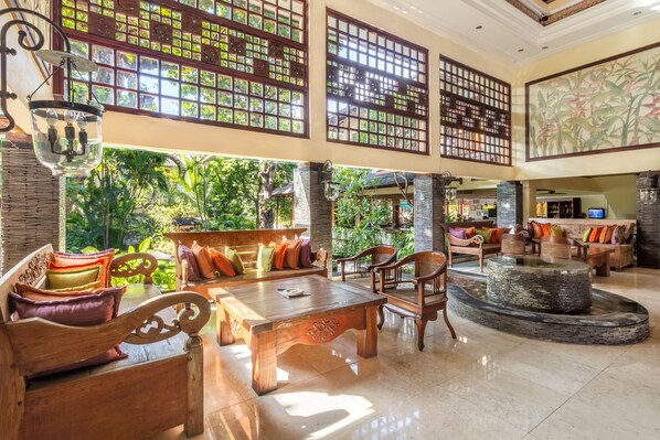 A spacious lobby with a wooden coffee table, seating area, and a decorative fountain. - Risata Bali Resort and Spa (Kuta)
