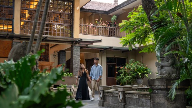 A courtyard with a stone balustrade, potted plants, and a statue. - Risata Bali Resort and Spa (Kuta)