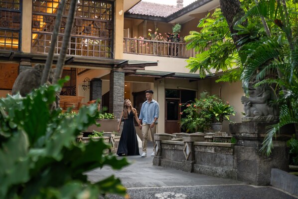 A courtyard with a stone balustrade, potted plants, and a statue. - Risata Bali Resort and Spa (Kuta)