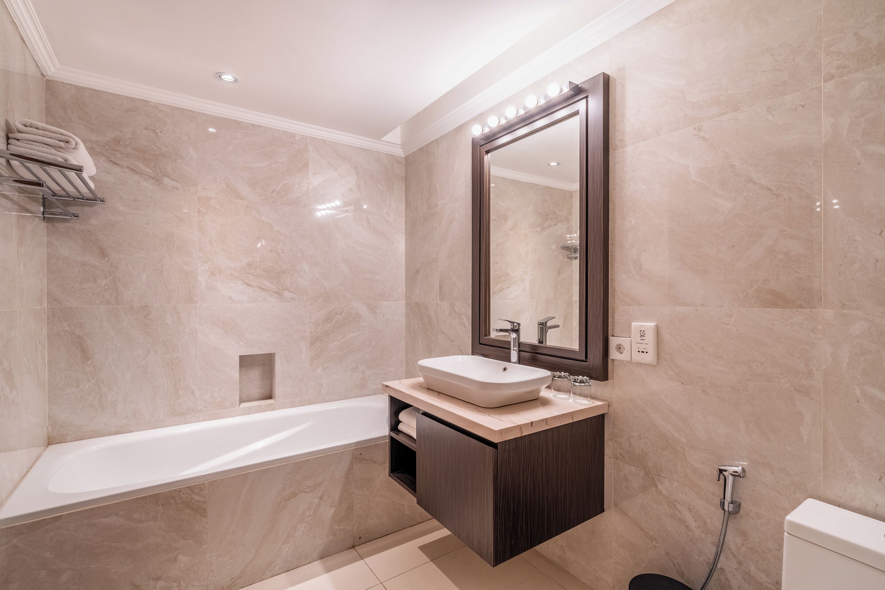 A modern bathroom with a freestanding bathtub, a vanity with a large mirror, and a toilet.