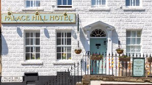 Um edifício branco com uma placa indicando "Palace Hill Hotel".