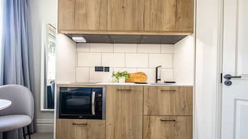 Estudio Deluxe, cocineta, planta baja | Cocina privada | Refrigerador, cafetera de espresso y cafetera y tetera