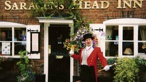 A brick building with the sign "SARAVELS HEAD INN" above the entrance. - The Saracens Head (Amersham)
