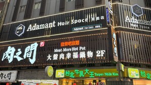 A multi-story building with various commercial establishments, including a hair salon named 'Adamant Hair Space'. - Han She Hotel (Taipei)