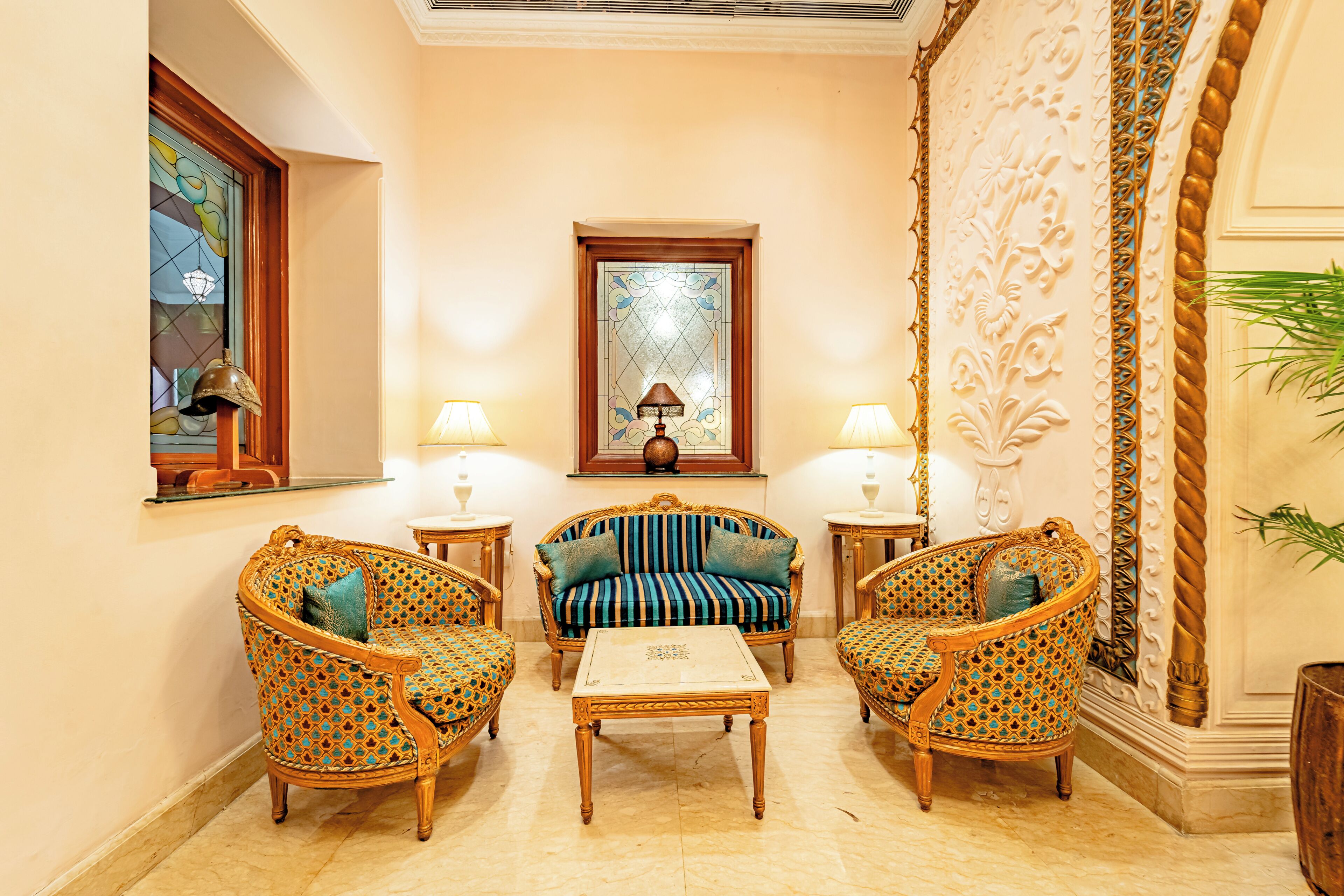 Una habitación con un sofá, dos sillones, una mesita de café y un espejo decorativo.