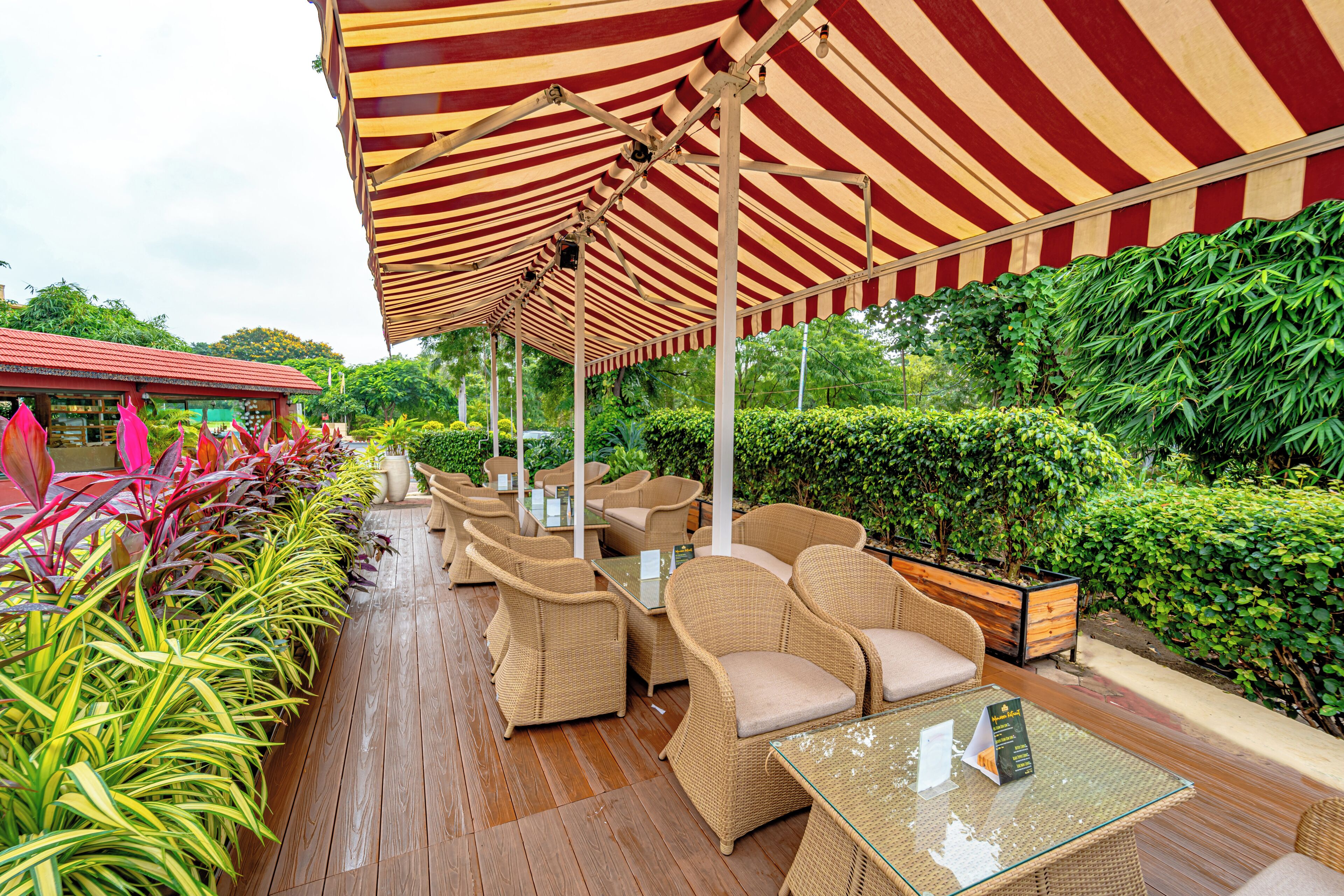 An outdoor seating area with wicker furniture and striped awnings.
