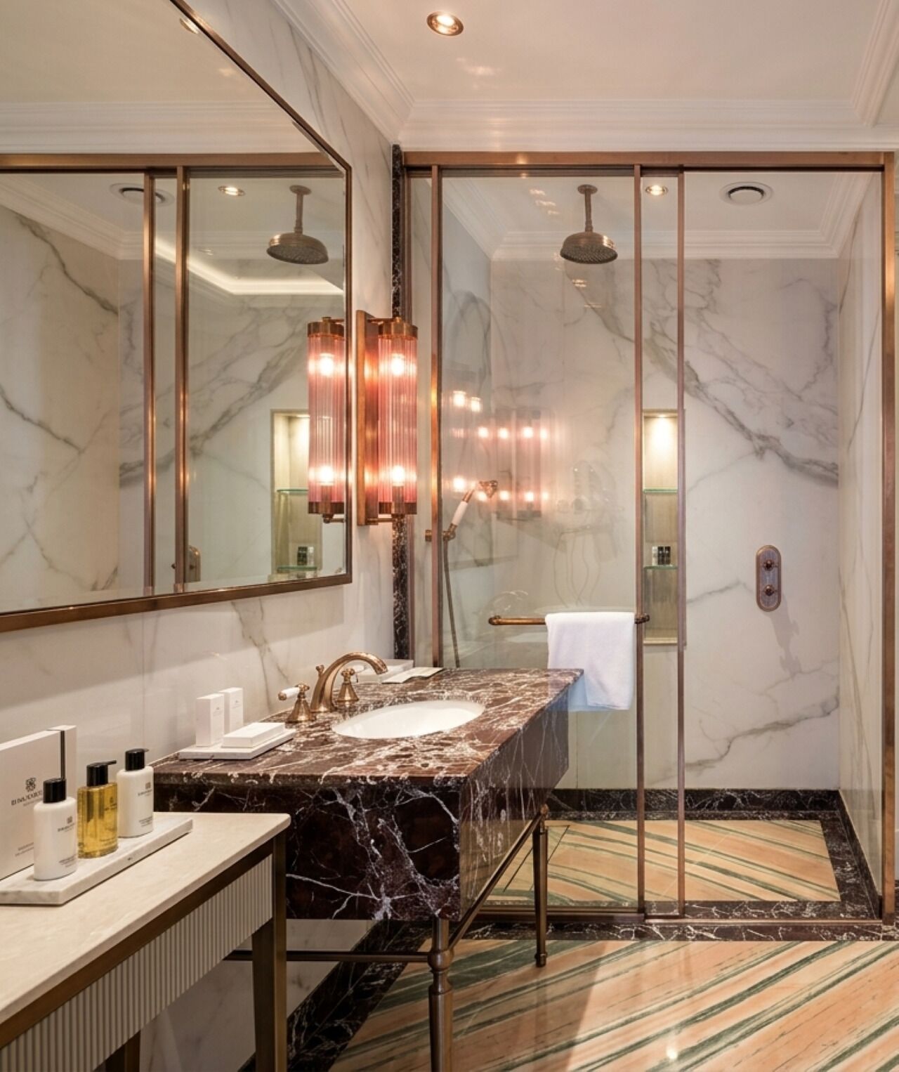 A bathroom with a marble vanity, a large mirror, and a shower with a glass door.