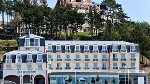 A hotel with multiple balconies, a marina, and a building with a red roof.