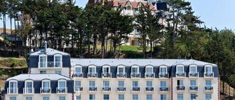 Un hôtel doté de nombreux balcons, d’un port de plaisance et d’un bâtiment au toit rouge.