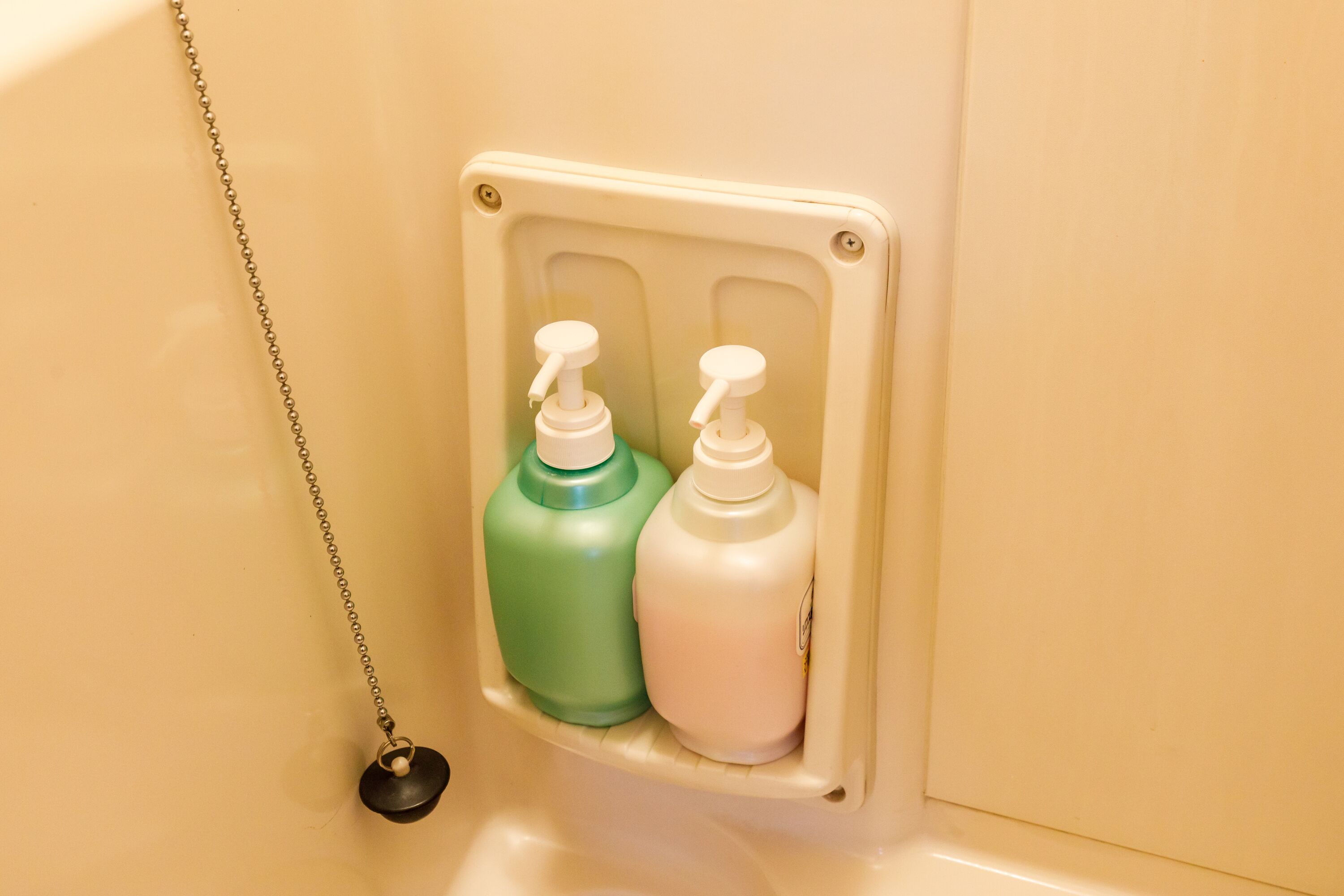 Une salle de bain avec un distributeur de savon fixé au mur.