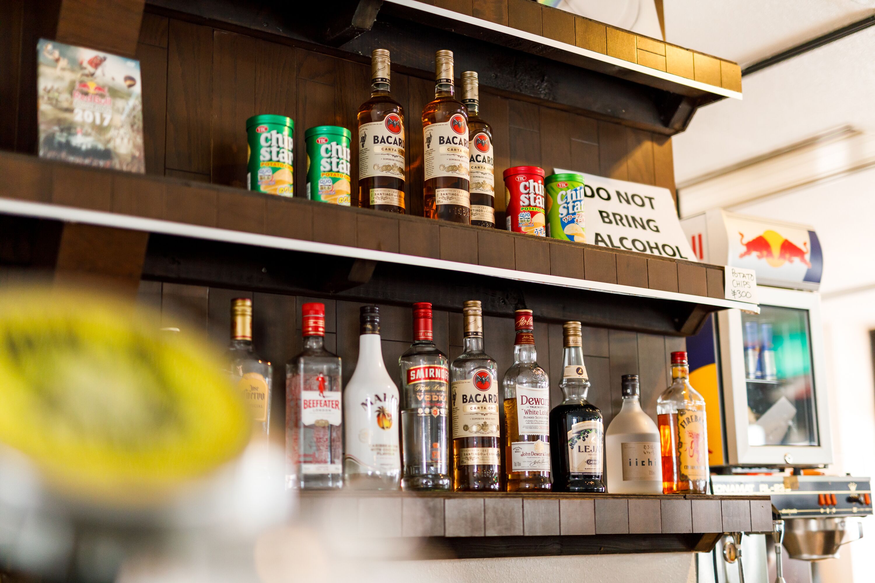 A bar with various liquor bottles and a sign prohibiting alcohol.