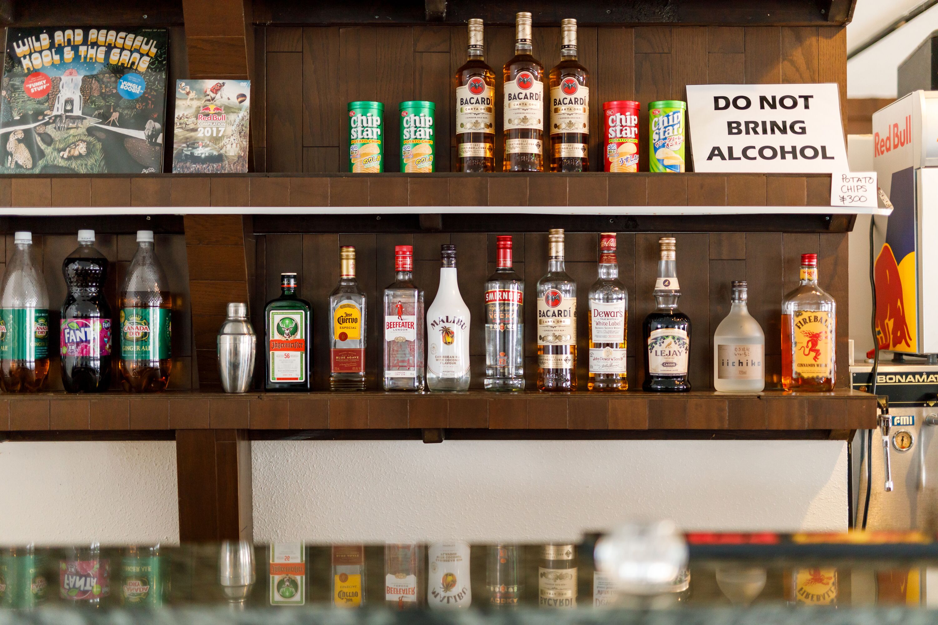 Una zona de bar con diferentes botellas de alcohol y aperitivos.