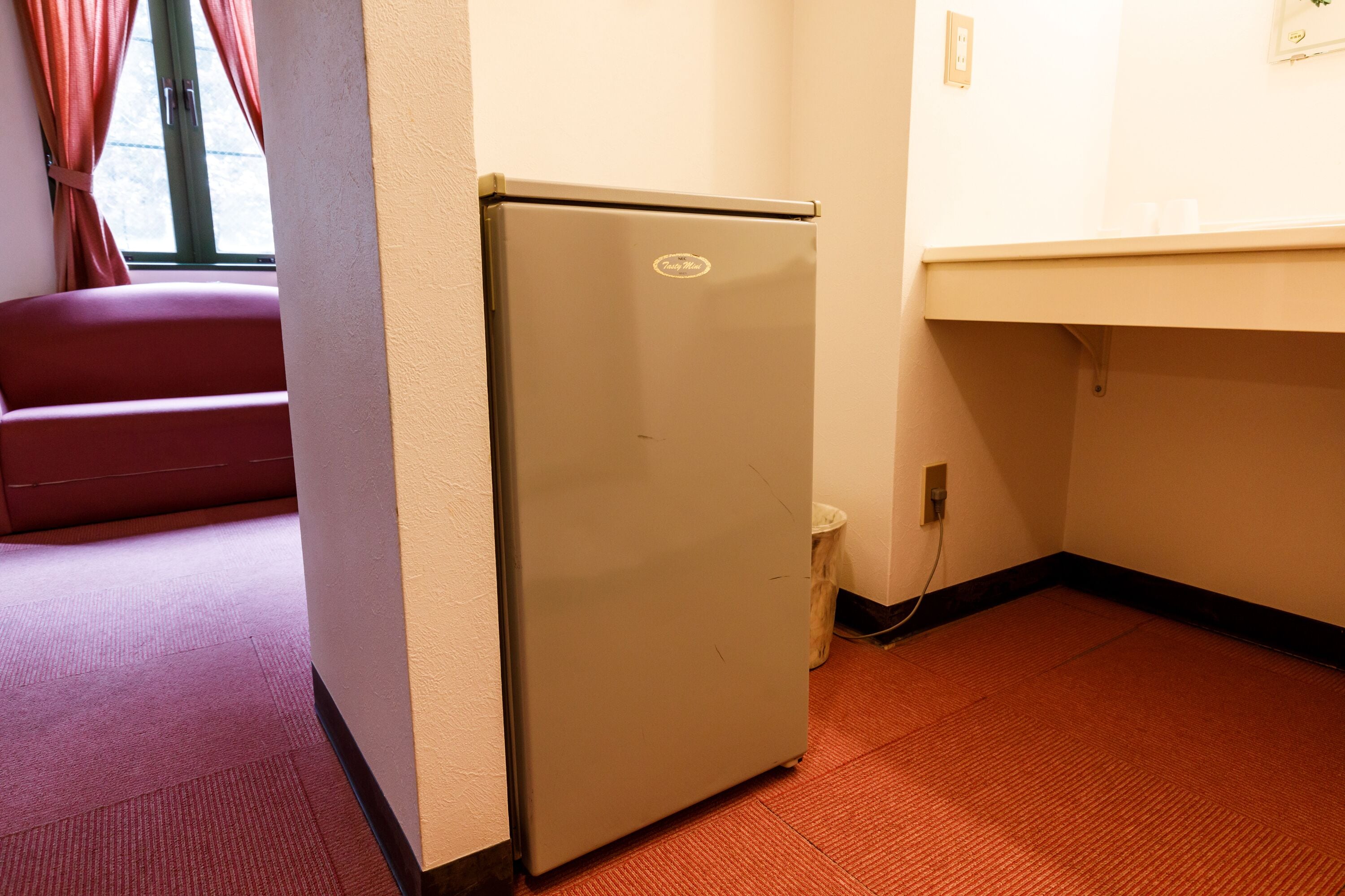 A small kitchenette with a refrigerator, a sink, and a countertop.