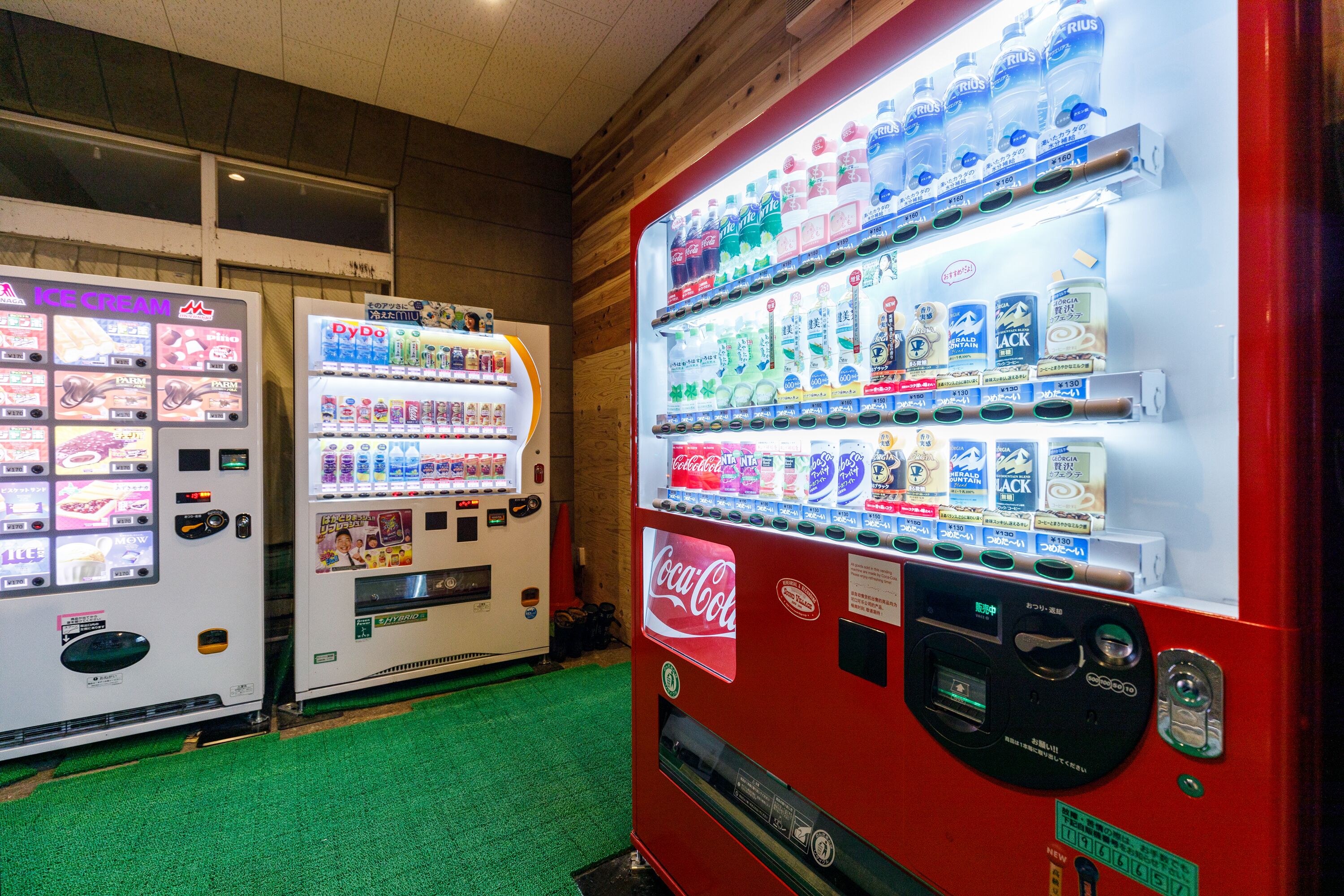 A vending machine area with various drink options including Coca-Cola and other beverages.