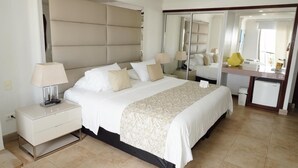 Una habitación de hotel moderna con una cama grande, mesitas de noche, un escritorio y un espejo.