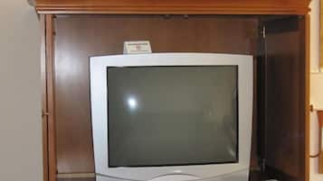 Un televisor en un mueble de madera con un cartel que indica zona para no fumadores.