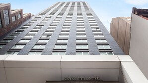 A high-rise building with a modern architectural design, featuring a prominent 'element by Westin' sign at the base.