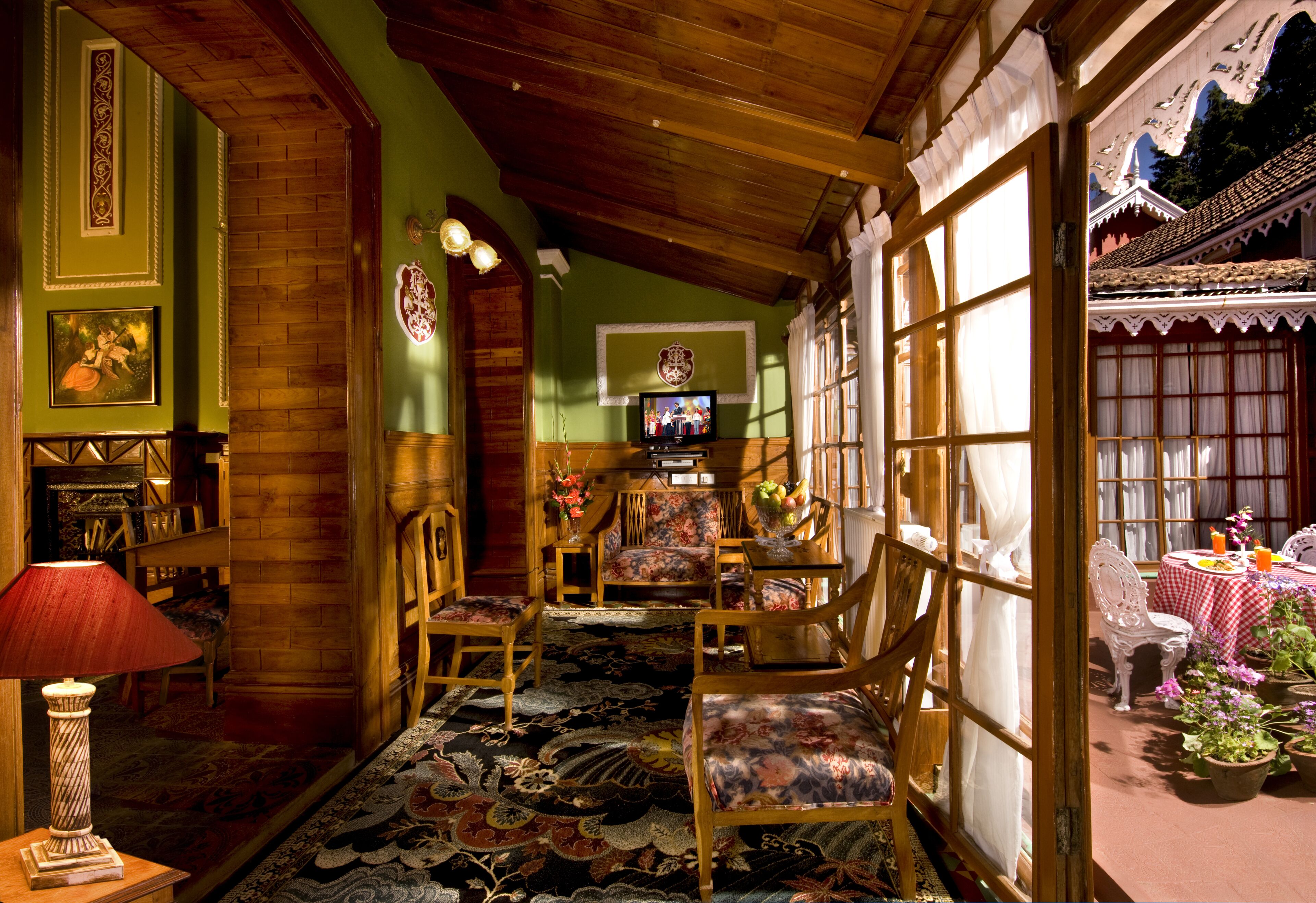A traditional room with wooden furniture, a television, and a dining area with a table and chairs.