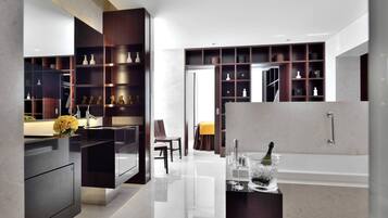 A modern bathroom with a large bathtub, a vanity with a mirror, and a shelf with decorative items.