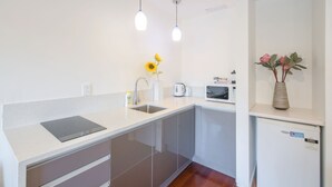 A modern kitchen with a countertop, sink, and a built-in microwave. - Auckland Newmarket Motel (Auckland)
