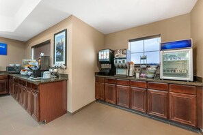 A hotel kitchen with a coffee station, a refrigerator, and a microwave.