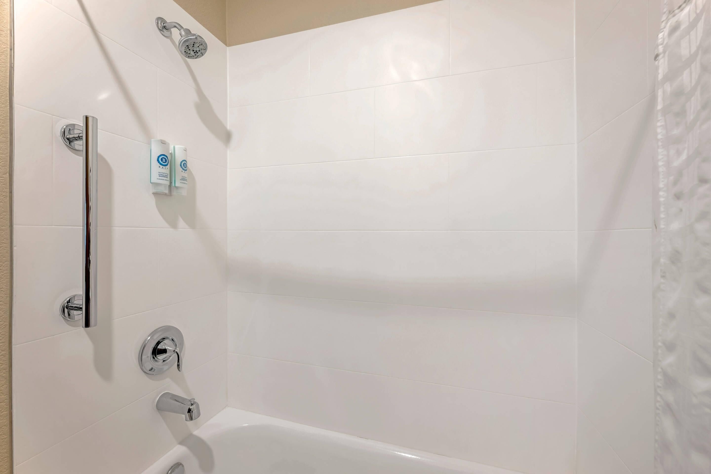 A modern bathroom with a bathtub, a shower, and a toilet.