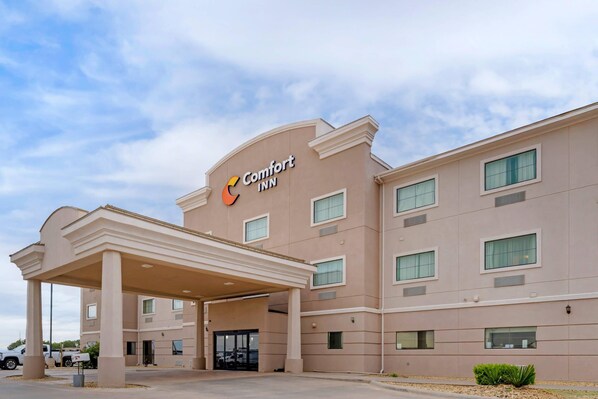 A Comfort Inn hotel with a covered entrance, multiple windows, and a beige facade. - Comfort Inn I-20 Midland Stanton (Stanton)