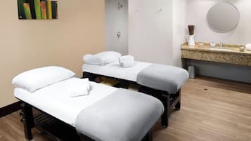 A room with two beds, a sink, and a mirror.